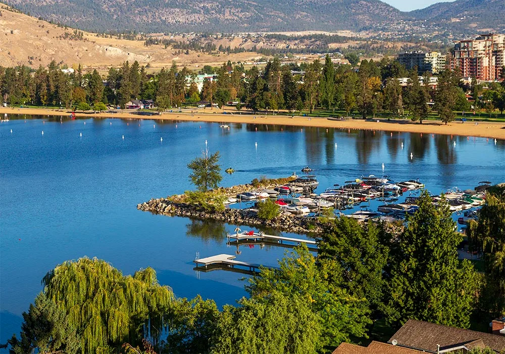 Tranquil Penticton lake scene featuring boats and stunning mountains, capturing the beauty of British Columbia's landscape.