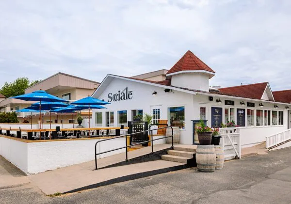 The front of Socialē, a local restaurant adorned with bright blue umbrellas, creating a welcoming atmosphere for outdoor diners.